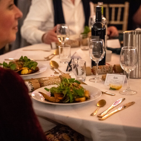 Guest sat at dinner table with a plate of food in front of them